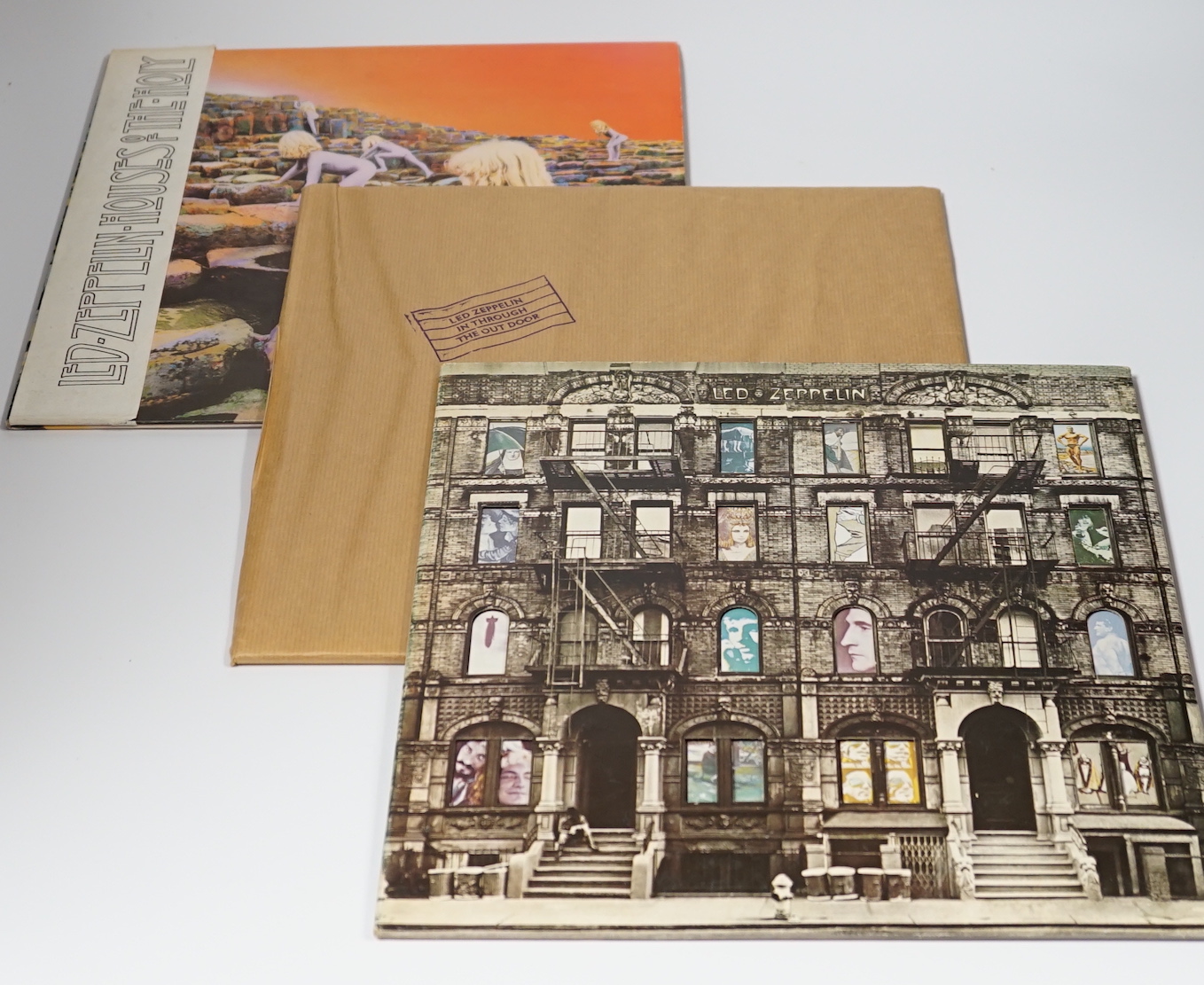 Three Led Zeppelin LP record albums; Physical Graffiti (SSK 89400), In Through the Out Door (SSK 59410) in brown paper wrapper, and Houses of the Holy (K50014) with original paper band